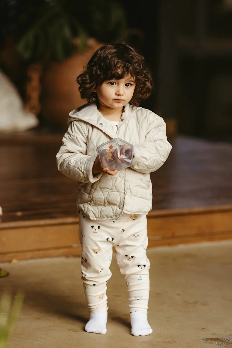 A cute child holds something in their hands.